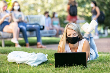Covid: Co-Ed Laying In Grass Taking Web Based Class