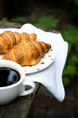 Coffee and croissants on old rustic wooden table