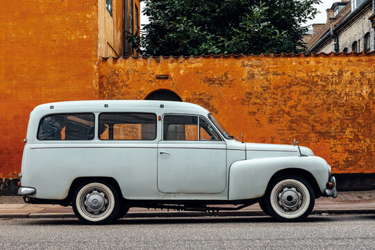 Old car parked in front of house wall