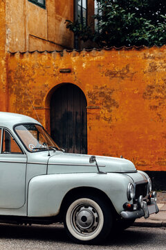 Old car parked in front of house wall