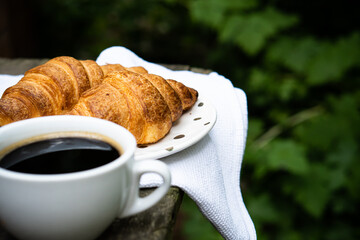 Coffee and croissants on old rustic wooden table