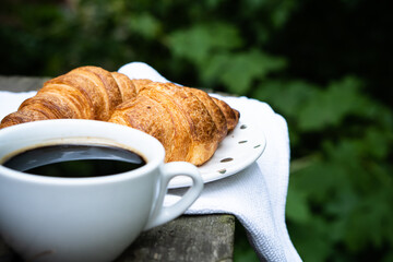 Coffee and croissants on old rustic wooden table