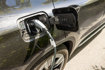 Close up view of electric cars with charging cable ready for charging. Technology, transportation and environment concept. Sweden. 