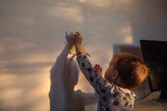 Boy hanging paper sun on a wall