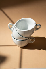 Three ceramic cups on beige studio background