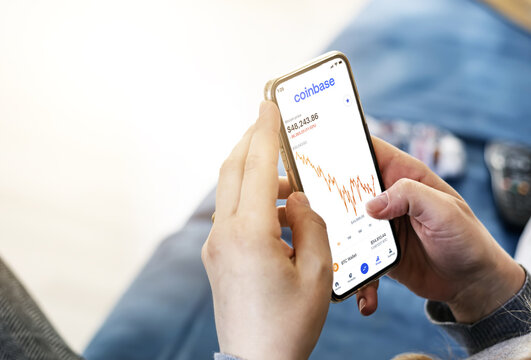 Woman checking cryptocurrency quotes on her smart phone using the Coinbase app