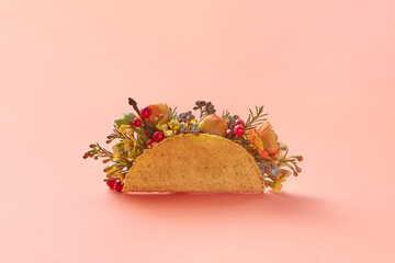 Taco with flowers on beige background