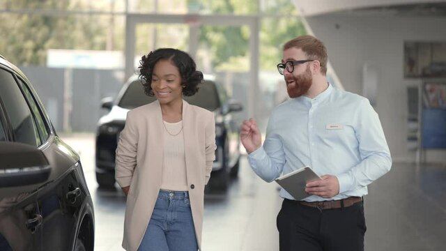 Manager with tablet consulting customer about new car