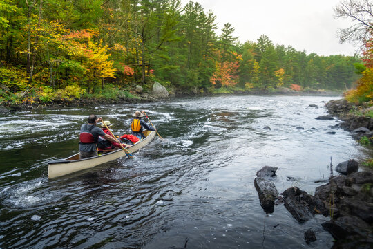 Paddling Canoe Through Rapids on Whitewater River Canoe Trip