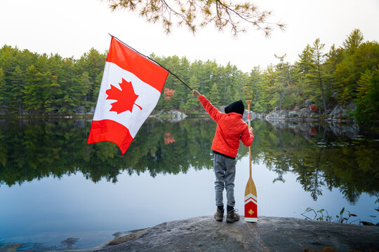 Boy Holding Canadian Flag on Back Country Camping Trip