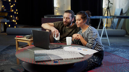 Two painters are watching something on the computer