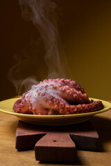 dish with a steaming freshly cooked whole octopus