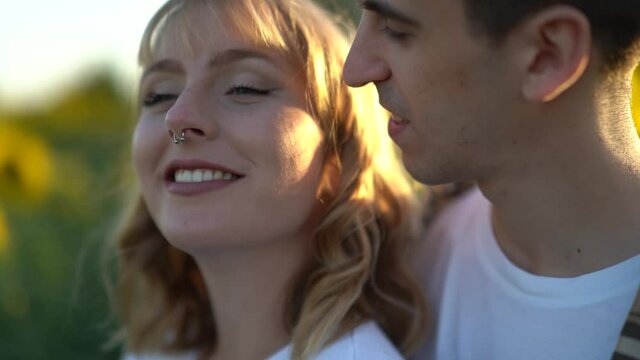 Pareja de chico y chica en campo de giraoles sonriendo y pasandolo bien