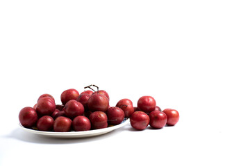group of plums on a plate with white background