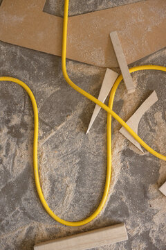 yellow power cord on floor with sawdust and wood