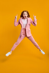 Fototapeta na wymiar Full length photo of funny caucasian lady in pink suit jumping up high see low shopping prices direct finger up on advert banner, isolated yellow color background in studio