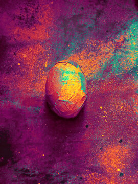 Rich, vibrant, colorful easter egg wrapped up in bright saturated pieces of paper
