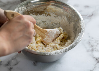 femme en train de mélanger une pâte fraichement préparée avec des ingrédients simples dans un...