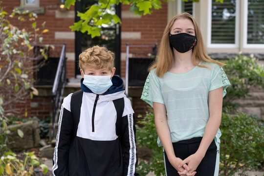 Teenage Boy and Girl Wearing Masks On First Day Back To Class During Shutdown