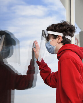 Boy in Face Mask Looking Through Window