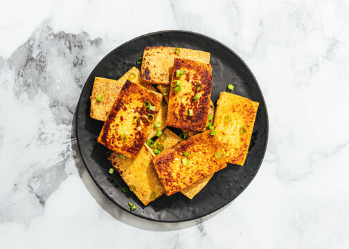 Plate of fried tofu and green onion garnish