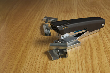 stapler for papers with their respective staples on wooden base with copy space