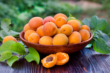 Fresh, ripe organic apricots in a bowl with leaves table