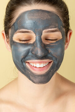 Beauty portrait of a young woman doing a facial skincare treatment with a clay mask 