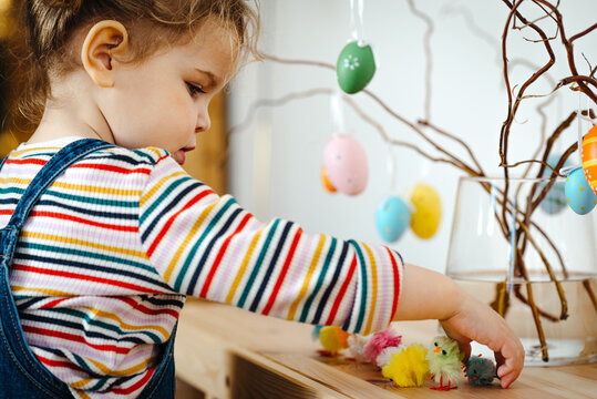 Toddler girl decorating for Easter