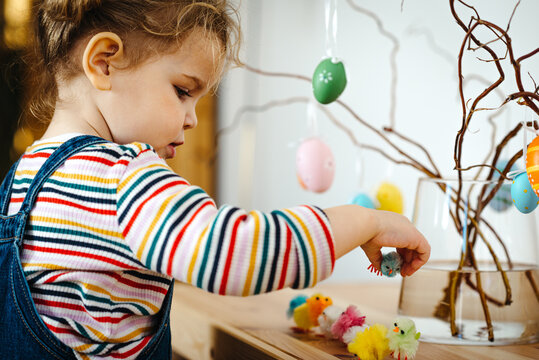 Toddler girl decorating for Easter