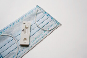 Covid-19 PCR test and medical face mask isolated on white background