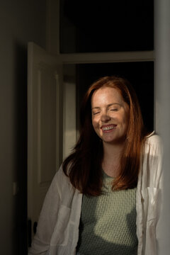 Ginger woman smiling with closed eyes