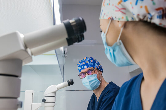 Professional embryologists communicating in IVF laboratory