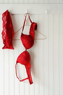 Red lace bras and panties hanging on hooks 