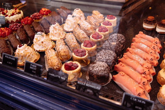 Fancy baked goods in a dessert case at a bakery including pigs