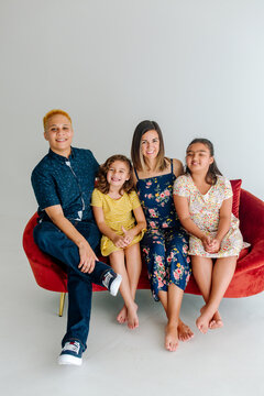Smiling family with bonus mom on sofa