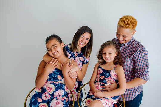 Mother and bonus mom hugging daughters