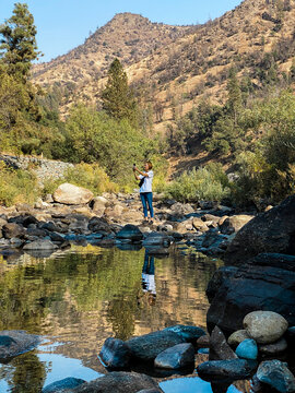 Female taking pictures on a beautiful creek in the mountains