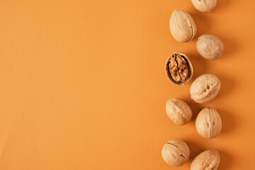 walnuts pattern on brown background, top view copy space