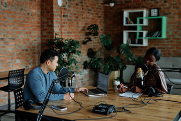 Man listening woman and recording podcast