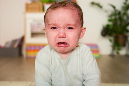 Crying cute baby on floor