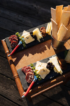 Salami and cheese slices on a black stone cheese plate