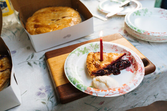 A slice of summer cherry pie sits on a paper plate at an outdoor party