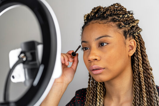 Black beauty blogger applying mascara