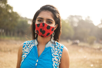 Yong Indian girl wearing colorful mask at outdoors