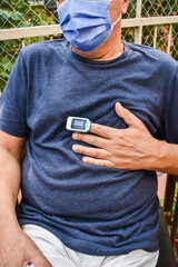 Mature Man Checking Oxygen saturation with Oximeter at Home