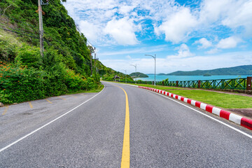 Fototapeta na wymiar The asphalt road around the phuket island Beautiful seashore in Sunny summer day season Amazing view blue sky background at Phuket Thailand.