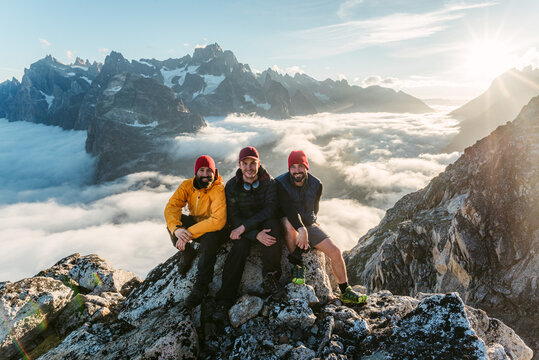 Cheerful travelers resting on mountain peak
