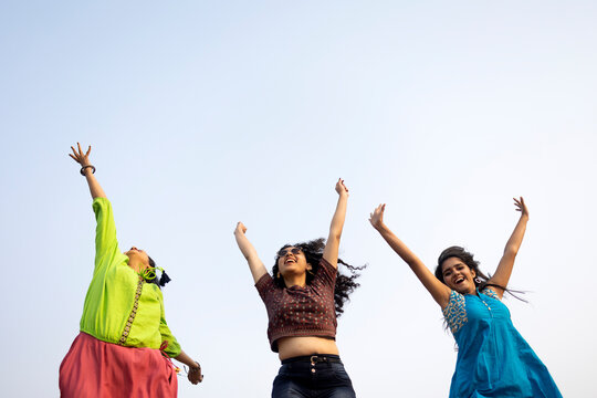 Three Indian friend running,jumping and spreading hands in Joy at outdoors