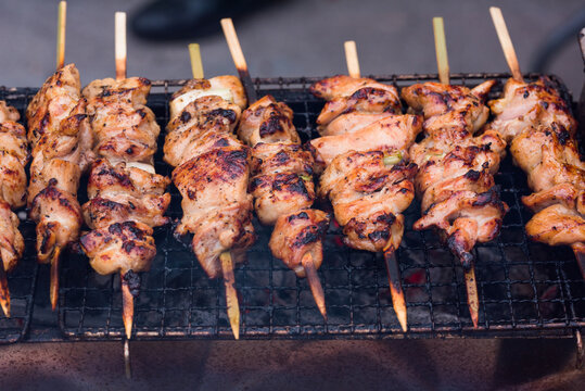 Chicken kebabs roasting on a grill